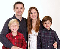 Parents and two children pose for a family photo.